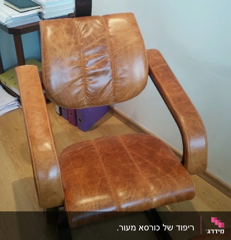 כיסא מרופד בעור חום עם משענות וראש